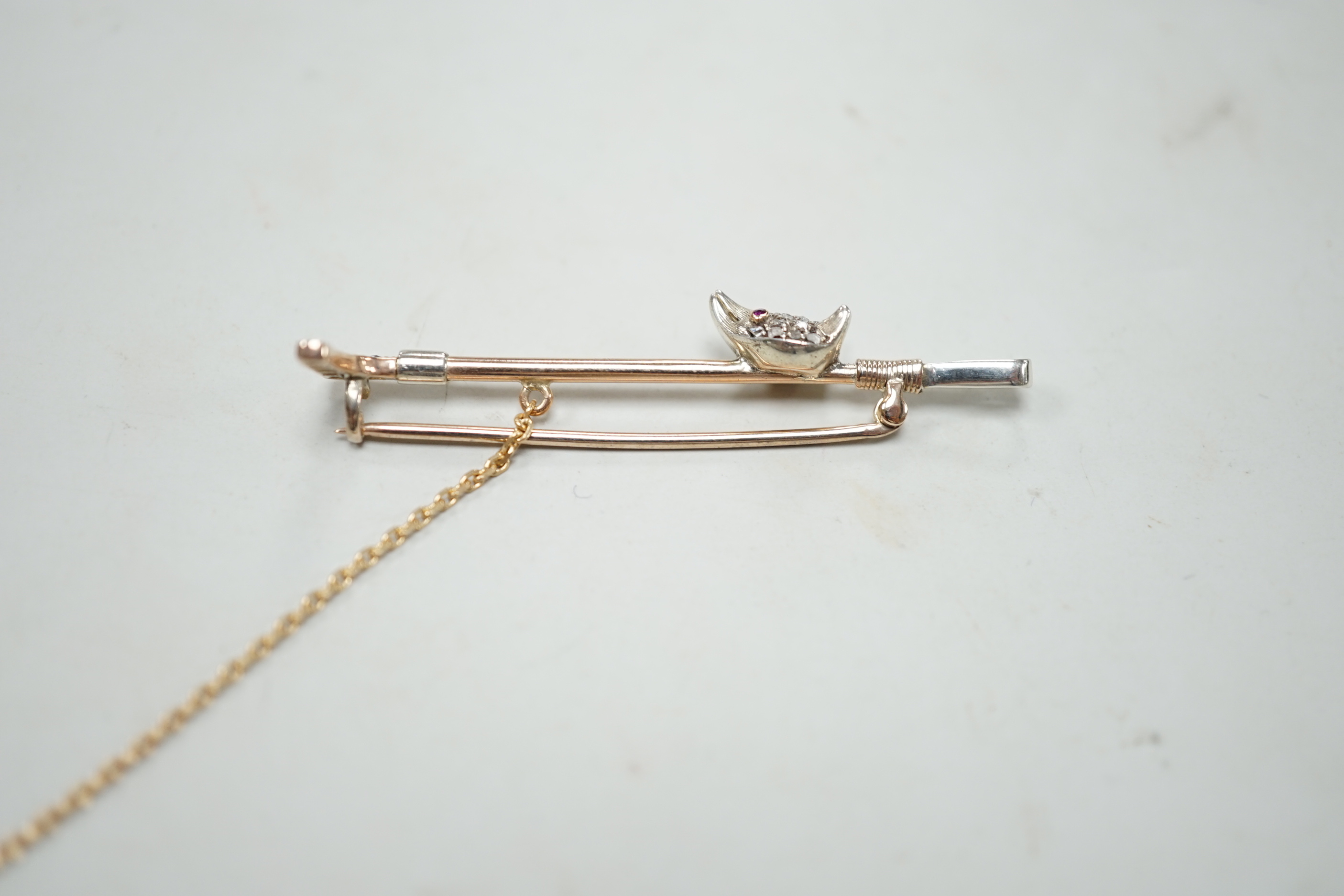 An Edwardian yellow metal, sapphire and diamond cluster fox head and riding crop bar brooch, with ruby set eyes, 52mm, gross weight 4.1 grams, in fitted box.